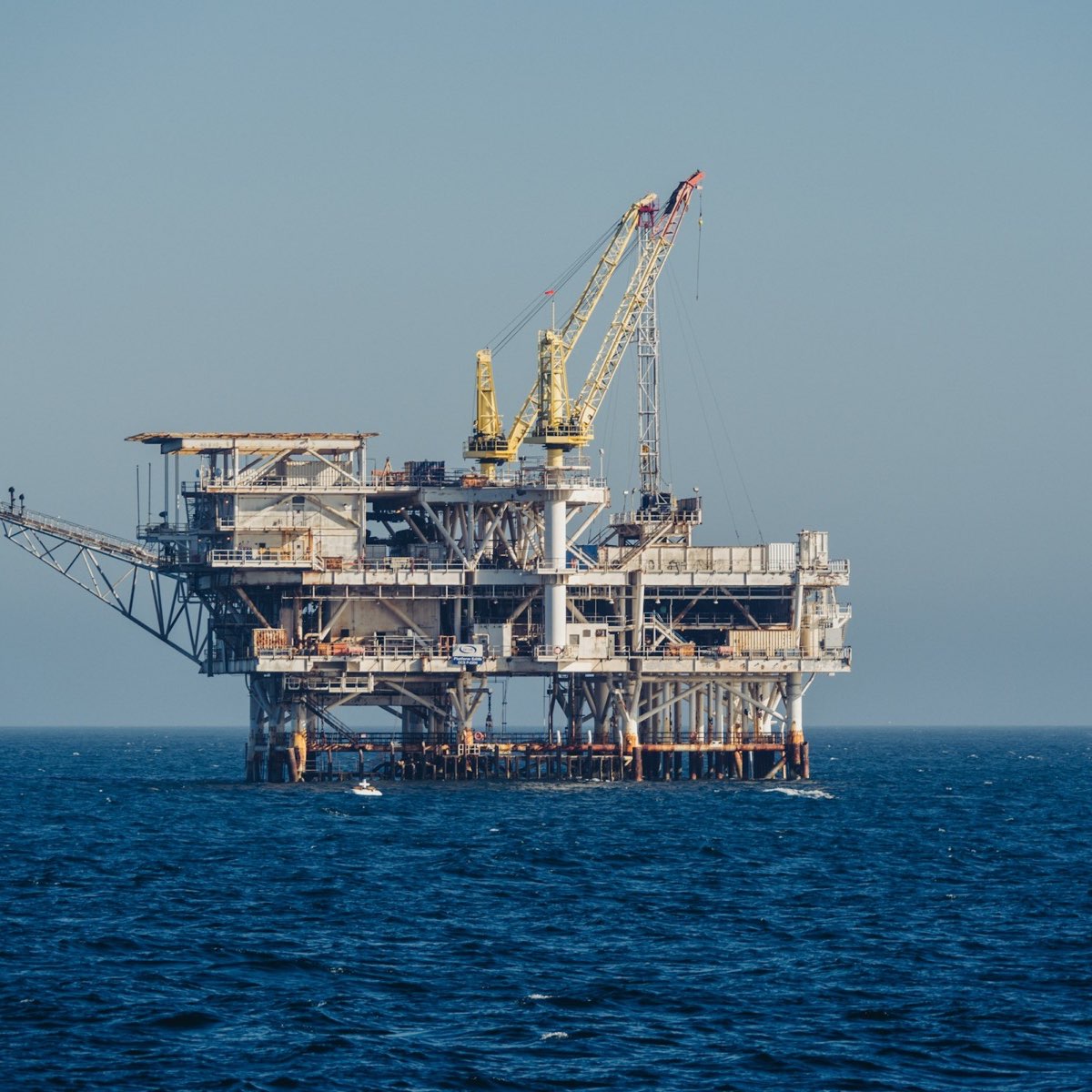 An offshore production platform standing in open blue water.